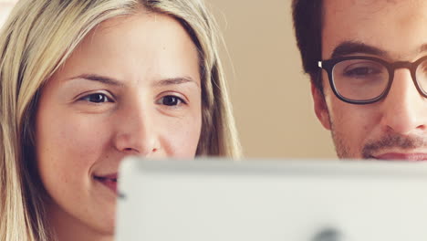 Happy-young-couple-watching-movie-on-digital-tablet-pc-computer-ipad